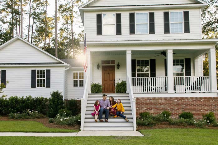 Family sitting on steps of single family home