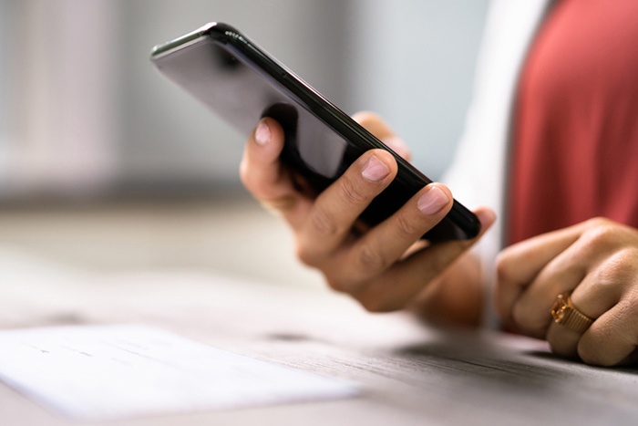 hand holding phone taking photo of check for mobile deposit