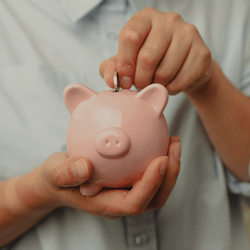 man putting coin into piggy bank